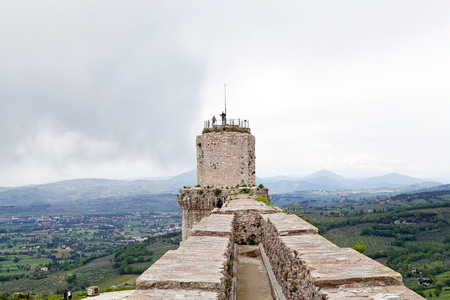 Tourists are visiting the Rocca Maggiore, Assisi, Italy, with panorama. Rocca Maggiore dominated by more than eight hundred years the citadel of Assisi and the valley of Tescio. The first documented regarding the fortress date back to 1173.のeditorial素材