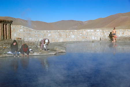 Tourists are taking a bath in a natural swimming pool at the El Tatio geysers, Chile. El Tatio is a geyser field located in the northern Chile. It is the largest geyser field in the southern hemisphere and the third geyser field in the world.のeditorial素材