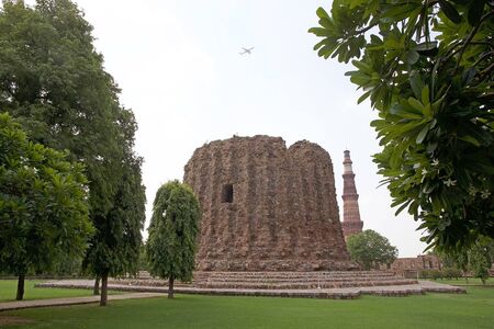 Alai Minar in with the Qutab Minar in the background in Delhi, India. It is a minaret, the construction was abandoned, that forms of the Qutab complex.の写真素材