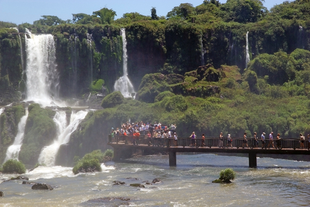 Footbridge and tourists at the Iguazu Falls, from the Brazil side. Iguazu Falls are waterfalls of Iguazu River on the border of the Argentine province of Misiones and the Brasilian state of Paranaの写真素材