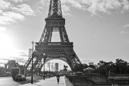 Black and white photo of the Eiffel Tower from the street level with people and cars.の写真素材