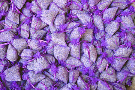 Many small purple sachets filled with dried lavender buds, tightly packed together in a vibrant and fragrant arrangement.の写真素材