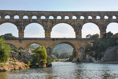 Front view of the Roman aqueduct Pont du Gard above the Gardon River in southern France, seen from water levelの写真素材