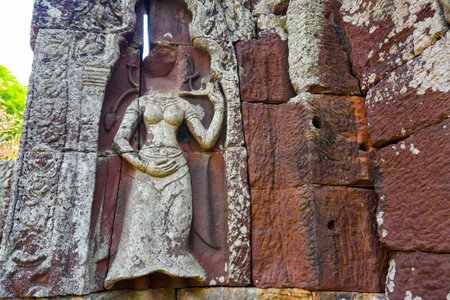 Ancient stone carving of a female deity or dancer on a temple wall, featuring intricate details and weathered texture.の写真素材