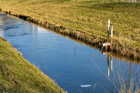 Beautiful dutch dike with grass on it and trees on the side.