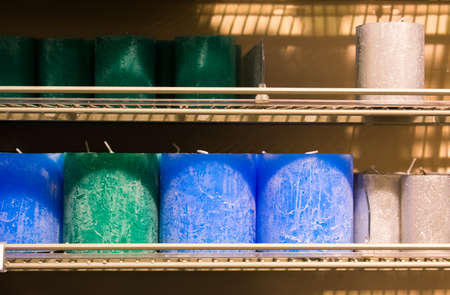 Candles on a shelf in a store nice and ordered and in different colors.の写真素材