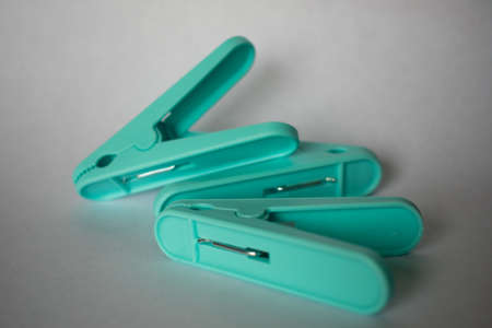 A handful of either blue or brown wooden clothespins on a white background.