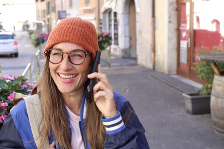 Cheerful woman calling while walking on the streetの写真素材