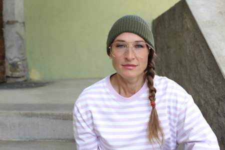 Woman bearing beanie, retro eyeglasses and braided hair