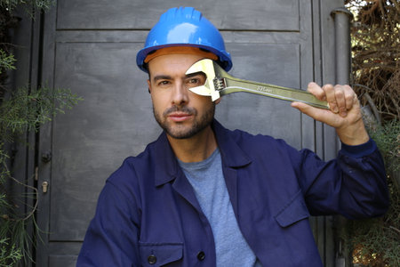 Maintenance worker holding large adjustable wrenchの写真素材