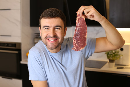 Meat lover showing a delicious raw steakの写真素材