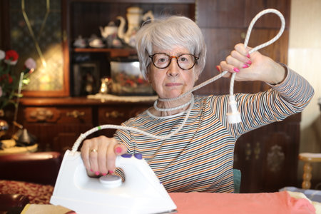 Senior woman who really dislikes ironing clothesの写真素材