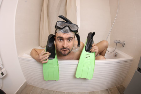 Humorous man snorkeling in the bathtub&nbsp;の写真素材