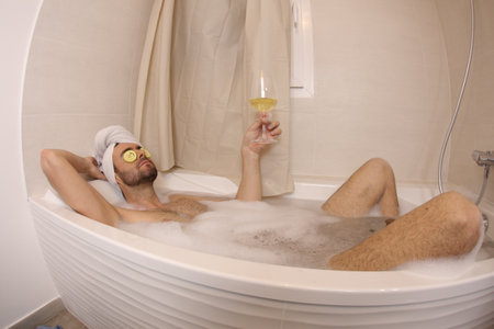 Man doing his beauty routine in the bathtubの写真素材