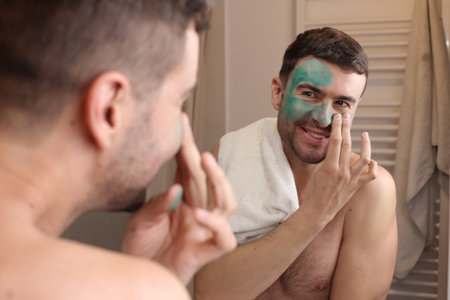 Man using a green beauty face maskの写真素材