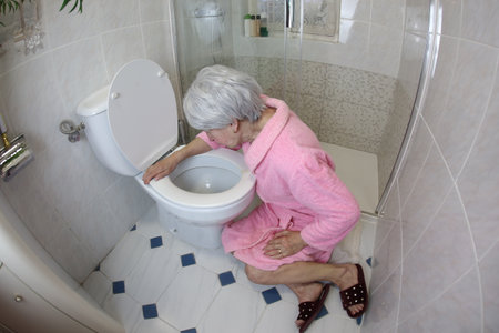 Senior woman vomiting in the bathroomの写真素材
