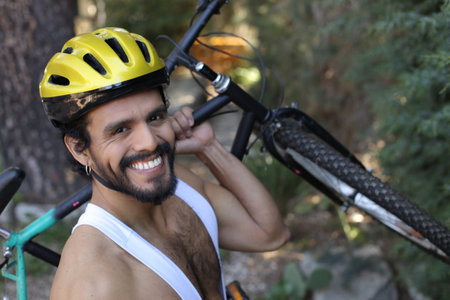 Muscular cyclist holding mountain bike on his shoulderの写真素材