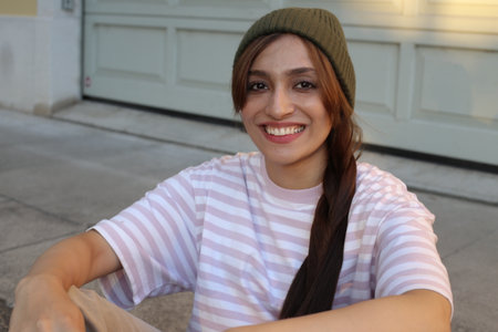 Fashionable woman wearing green beanie and striped pink and white t-shirt