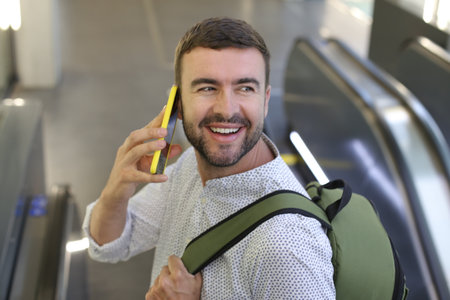 Man talking on the phone while using the escalators