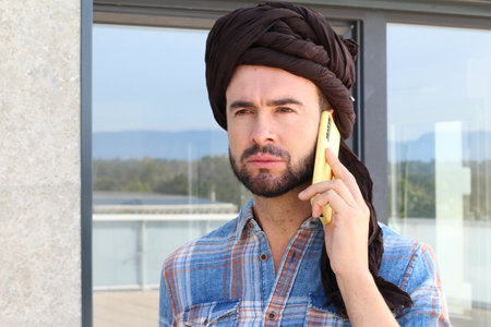 Spiritual wearing a turban and making a phone callの写真素材