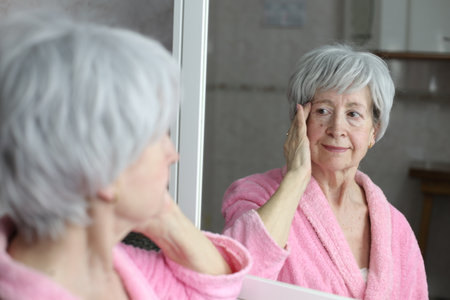Senior proud of herself in front of  the mirrorの写真素材