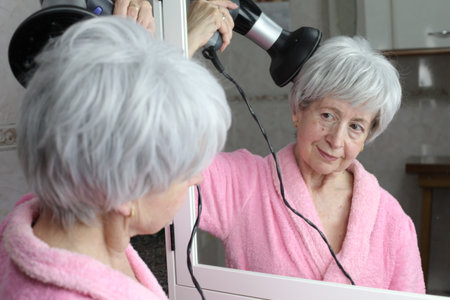 Mature woman drying her hairの写真素材