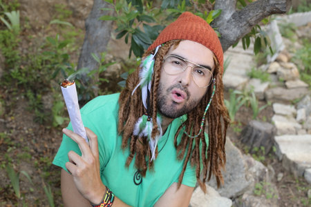 Hilarious man pretending to smoke an extra large jointの写真素材