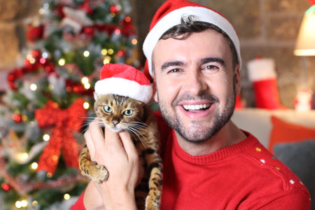 Man holding his evil cat during Christmasの写真素材
