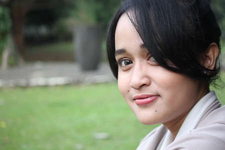 A beautiful girl smiling in a gardenの写真素材