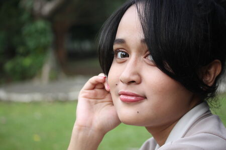 A beautiful girl smiling in a gardenの写真素材