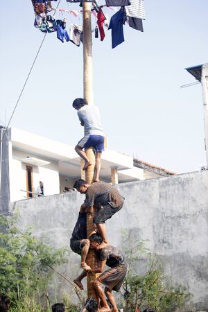 Depok, West Java, Indonesia, 17 August 2016 - Participants race to reach the peak of the pole as part the country's Independence Day celebrations in Depok, West Java, Indonesia on August 17, 2016.のeditorial素材