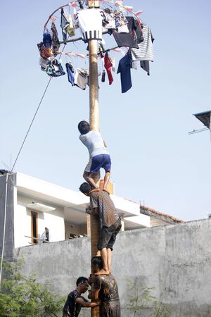 Depok, West Java, Indonesia, 17 August 2016 - Participants race to reach the peak of the pole as part the country's Independence Day celebrations in Depok, West Java, Indonesia on August 17, 2016.のeditorial素材