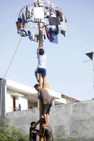Depok, West Java, Indonesia, 17 August 2016 - Participants race to reach the peak of the pole as part the country's Independence Day celebrations in Depok, West Java, Indonesia on August 17, 2016.のeditorial素材