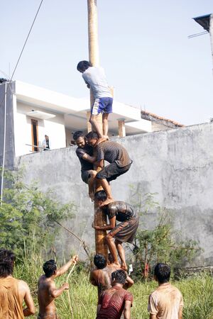 Depok, West Java, Indonesia, 17 August 2016 - Participants race to reach the peak of the pole as part the country's Independence Day celebrations in Depok, West Java, Indonesia on August 17, 2016.のeditorial素材