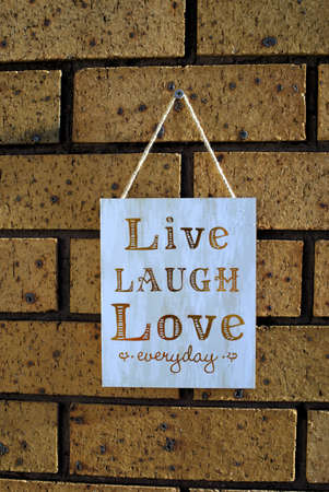 Wall hanging 'Live Laugh Love Everyday' shot in golden hour natural lightの写真素材