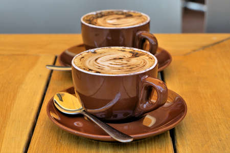 Two Cups of Barista coffee Cappuccino. Selective focus barista made Cappuccino coffee on table.の写真素材