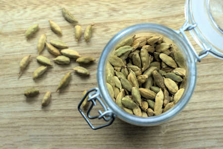 Cardamom in jar. Shot from top, Close up with selective focus. Dried pods of green Cardamom pods is an expensive spice used in Indian subcontinent food and drinks for fragrance and unique flavor. Also spelled as cardamum.の写真素材