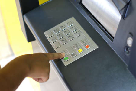 Person using ATM. Image of hand of person pressing number buttons to enter pin code for bank ATM....