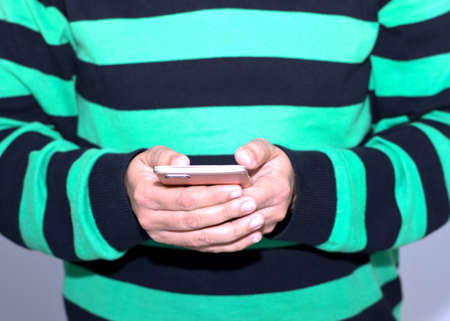 Man using smartphone. Man holding mobile phone in hands. Cellphone use.の写真素材