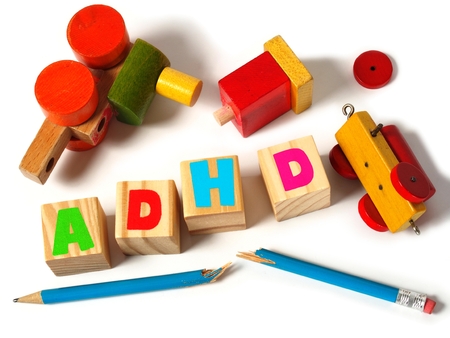 Broken toys and wooden blocks with letters ADHDの写真素材