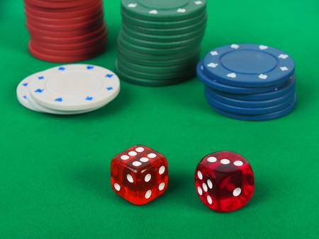 Dice and casino tokens on green table