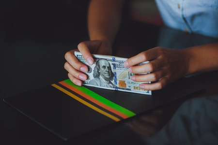 Money in human hands, women counting a lot of 100 dollars, with business folders , on a black...