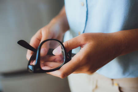 Human hands woman holding retro style eyeglassesの写真素材
