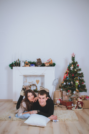 couple man and woman hugging, lie near the Christmas treeの写真素材