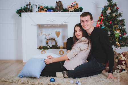 couple man and woman hugging, lie near the Christmas treeの写真素材