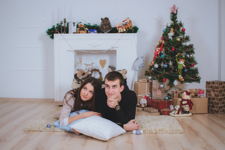 couple man and woman hugging, lie near the Christmas treeの写真素材