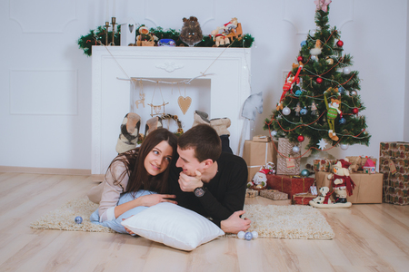 couple man and woman hugging, lie near the Christmas treeの写真素材