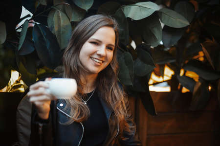 Young attractive girl drinking coffee and smiling