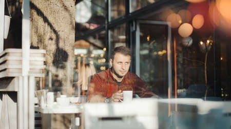 Young attractive man drinking coffee at lunch timeの写真素材
