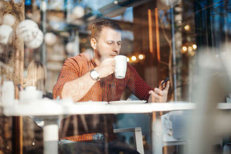 Young attractive man drinking coffee at lunch timeの写真素材